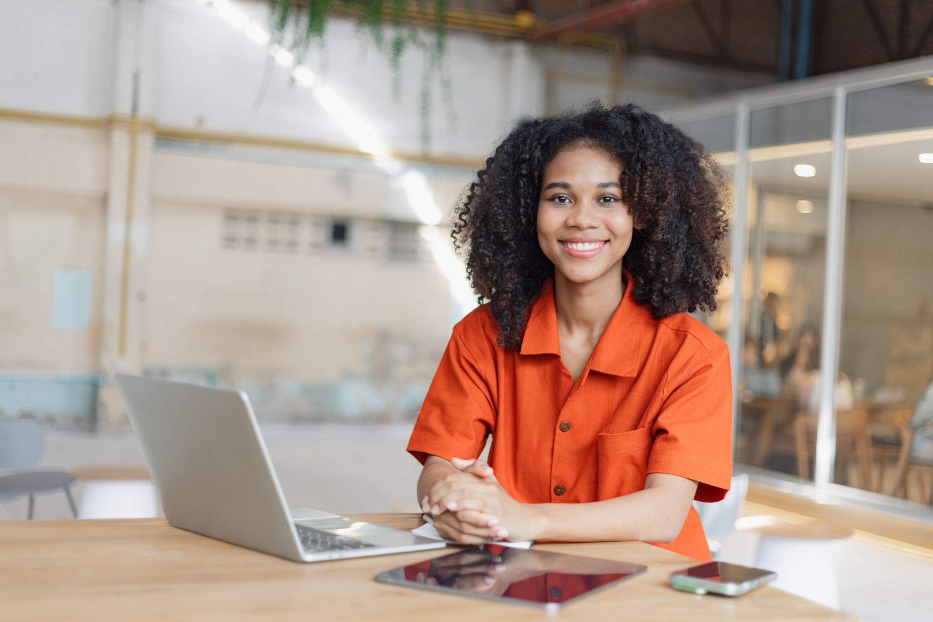 Happy smiling young African American woman with a laptop looking at camera.